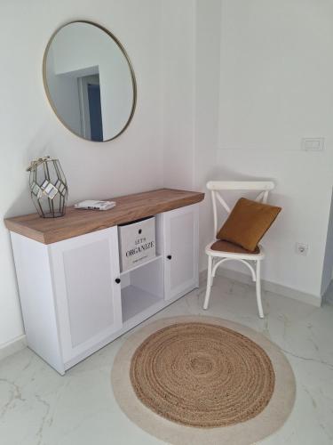 a dressing table with a mirror and a chair at Apartmani Jerka in Vinišće