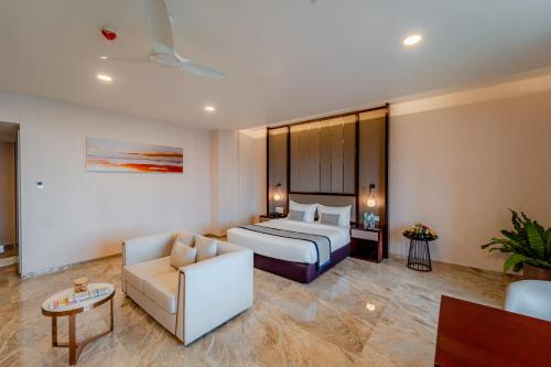 a hotel room with a bed and a couch at Pravasa Hotel Vijayapura in Bijāpur