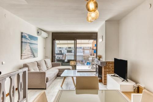 a living room with a couch and a tv at Port Empúries in Empuriabrava