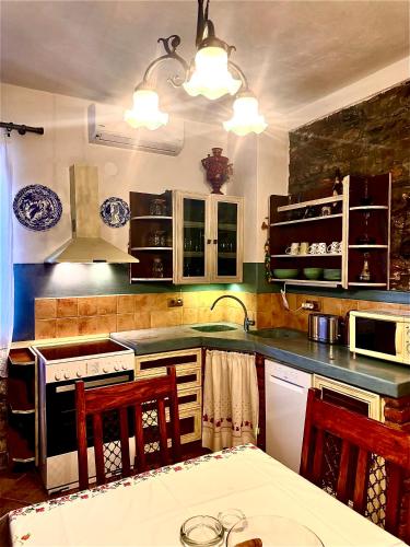 a kitchen with a stove and a table with chairs at Fathers house in Ayios Nikolaos Sithonia