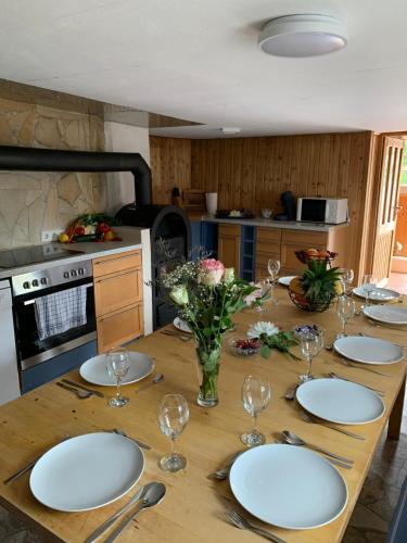 a wooden table with plates and wine glasses on it at Idyllisches Jurahäusle - Sauna&Whirlpool für 2-12 Personen in Treuchtlingen