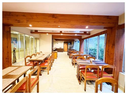 an empty restaurant with wooden tables and chairs at Darjeeling Mall is 700 m From Apsara Darjeeling Pure veg in Darjeeling