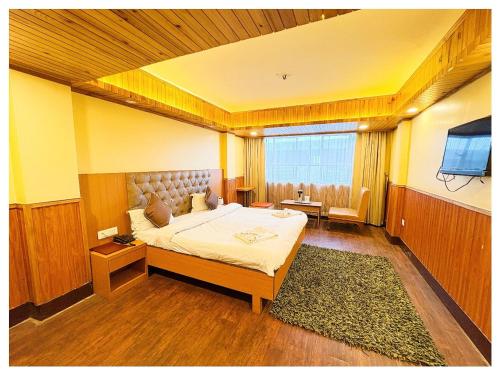 a bedroom with a bed and a television in it at Darjeeling Mall is 700 m From Apsara Darjeeling Pure veg in Darjeeling