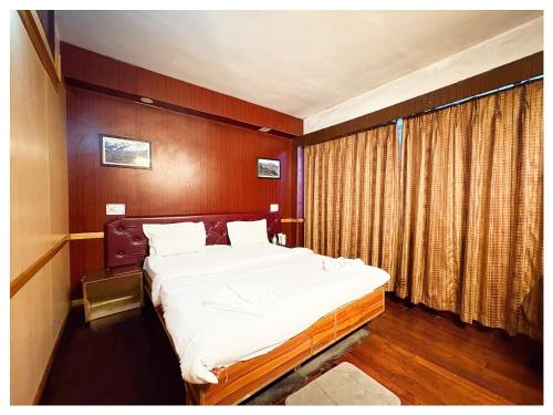 a bedroom with a large bed in a room at Darjeeling Mall is 700 m From Apsara Darjeeling Pure veg in Darjeeling