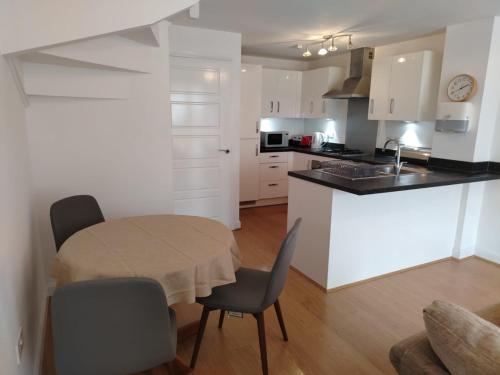 Una cocina con una mesa y sillas en una habitación. en Diadem Comfort Suites, en Dartford