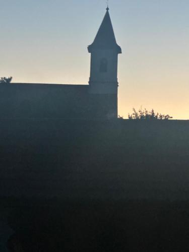 a clock tower on top of a building at sunset at Casa Adi Sucevița in Voivodeasa