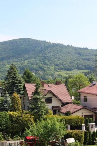 a group of houses with a mountain in the background at Bastówka Apartamenty in Ustroń