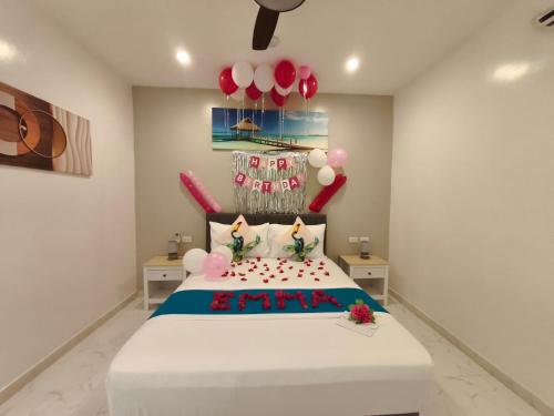 a bedroom with a bed with balloons and a cake at Selectum Mangrove Resort in Panglao