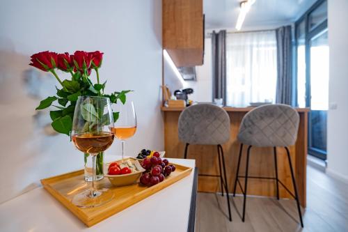 een tafel met een vaas met bloemen en een glas wijn bij Sea Paradise Studio in Mamaia Nord – Năvodari