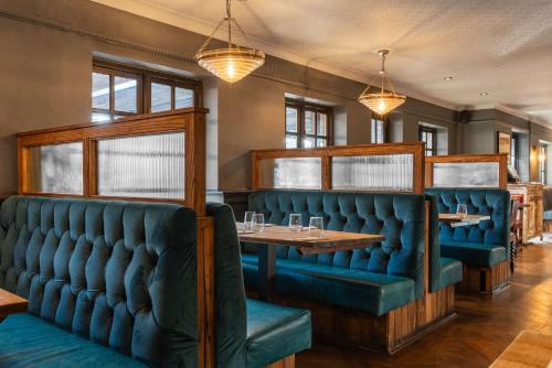 a dining room with blue seats and a table at The Huntsman of Brockenhurst in Brockenhurst