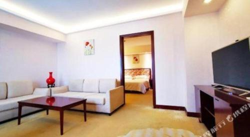 a living room with a white couch and a television at Starmoon Hotel in Beijing