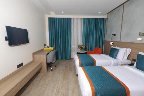 a hotel room with two beds and a flat screen tv at Zone Connect by The Park Patna 