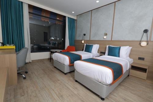 a hotel room with two beds and a desk at Zone Connect by The Park Patna 