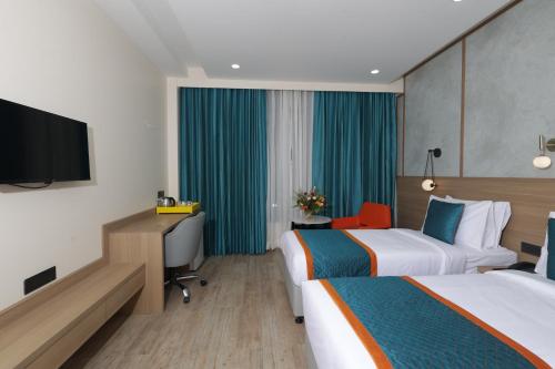 a hotel room with two beds and a flat screen tv at Zone Connect by The Park Patna 
