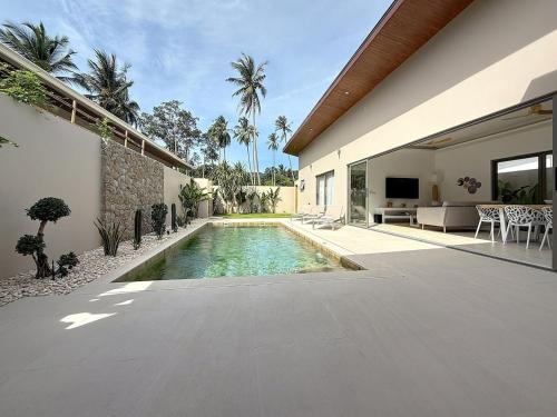 a swimming pool in the backyard of a house at Villa Panad 3BR Balinese Style in Amphoe Koh Samui