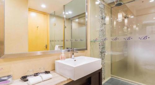 a bathroom with a white sink and a shower at The Bauhinia in Shenzhen