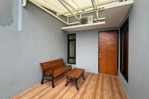 a wooden bench in a room with a door at Rooms at Deceva by Panorama Villas, Batu Malang in Batu
