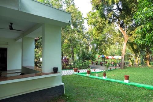a view of the garden from the outside of a house at Aqualillies Water Front Heritage Homestay in Kumarakom
