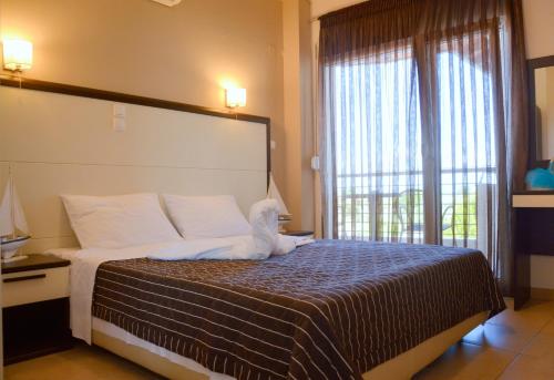 a bedroom with a bed with a white dog on it at Rodolithos Beach in Stavros