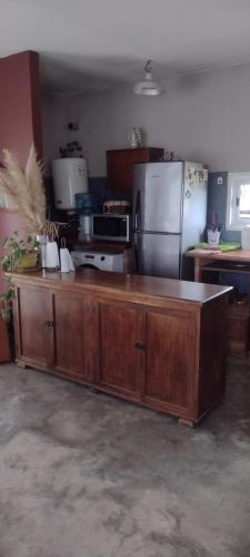 a kitchen with a large wooden counter with a refrigerator at Casa Quinta San Miguel del Monte in San Miguel del Monte