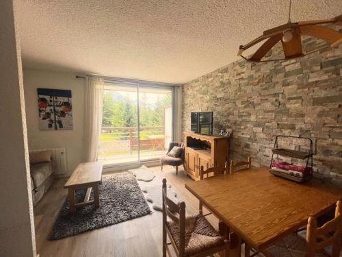 un salon avec une table et un mur en pierre dans l'établissement Résidence Cote Brune 3 - Superbe studio rénové au pied des pistes MAE-5661, à Vénosc