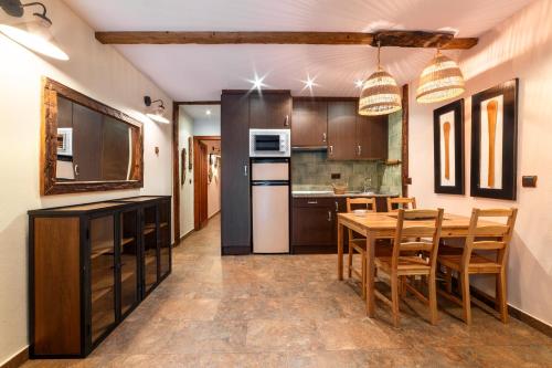 a kitchen with a table and chairs in a room at Apartamentos Rurales & Spa La Bárcena in Enterria