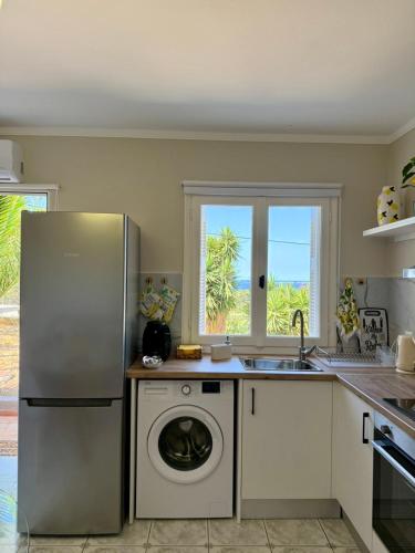 a kitchen with a refrigerator and a washing machine at Casa Limone in Argostoli