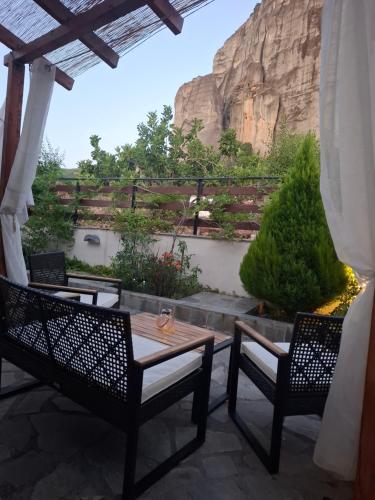 a patio with a table and two chairs and a mountain at Paradise of Meteora B in Kastrákion