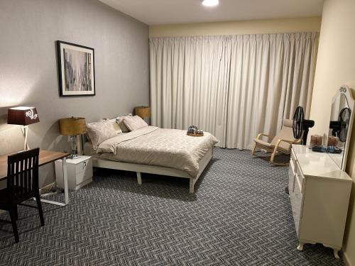 Apartment in Ajman في عجمان: غرفة فندق بها سرير ومكتب