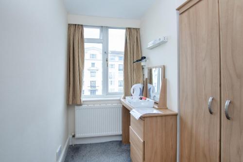 a bathroom with a sink and a mirror and a window at Dancenter Seaside Retreat Poole in Bournemouth
