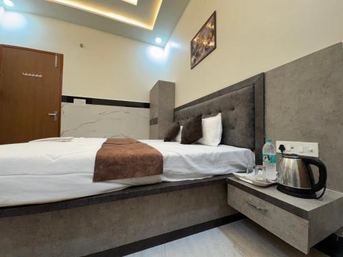 a hotel room with a large bed and a tv at Satya Nikunj INN in Vrindāvan