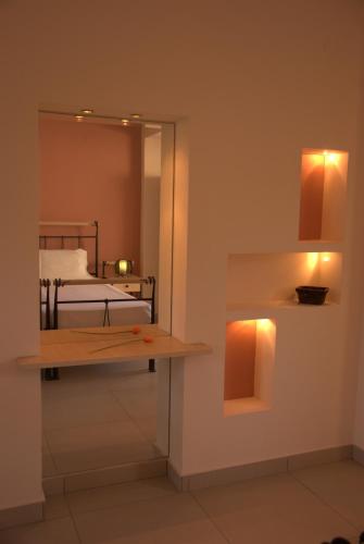 a room with a bed and a mirror and a table at Corfu Pearl in Liapades
