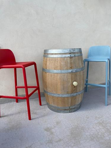a wooden barrel with two chairs and a red chair at La casa di Noah in Bene Vagienna