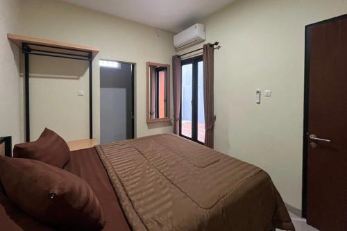a bedroom with a large bed in a room at Rooms at Deceva by Panorama Villas, Batu Malang in Batu