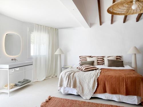 a white bedroom with a bed and a mirror at NEW villa - luxury, views, hot tub, pool, 8 plus sofabed in Cómpeta