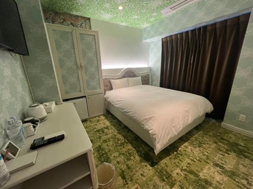 a small bedroom with a bed and a desk at Hotaku HOTEL Akihabara in Tokyo