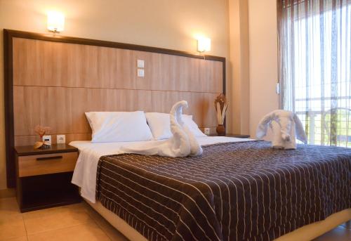 a bedroom with a bed with stuffed animals on it at Rodolithos Beach in Stavros