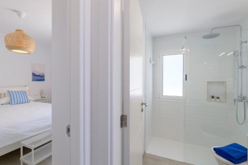 a white bathroom with a shower and a bed at Playa de Guacimeta - Maresia in Playa Honda