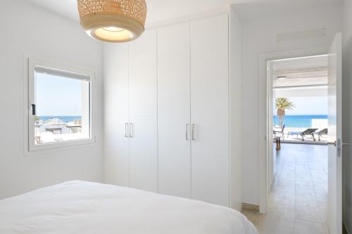 a white bedroom with a bed and a view of the ocean at Playa de Guacimeta - Maresia in Playa Honda