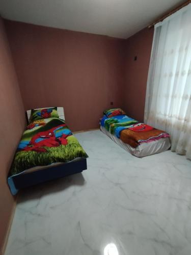 two beds sitting in a room with a window at Ilhamin bagi in Mardakan