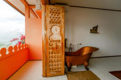a bathroom with a wooden door with a bath tub at La Marrocco Villas in Nusa Penida