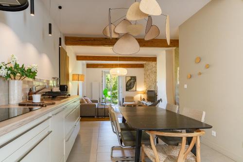 une cuisine et une salle à manger avec une table et des chaises dans l'établissement Appartement Aux Portes Du Vercors, à Pont-en-Royans