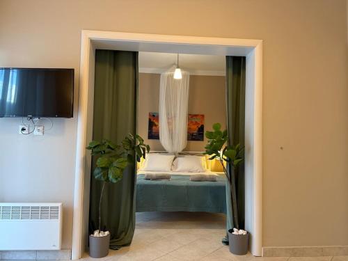 a bedroom with a bed with green curtains and plants at Endless summer,Agia Triada in Agia Triada