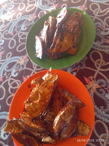 two plates of food sitting on a table at Three Ken Homestay & Cafe in Manado