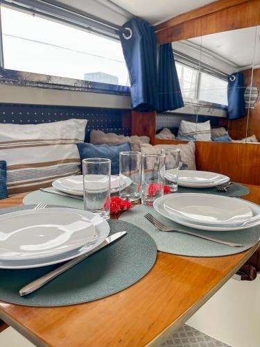 une table avec des assiettes et des verres au-dessus dans l'établissement Nuit Insolite sur un Bateau au Cœur de Bordeaux, à Bordeaux