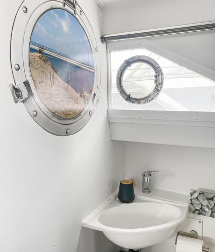 une salle de bain avec un miroir et un lavabo dans l'établissement Nuit Insolite sur un Bateau au Cœur de Bordeaux, à Bordeaux