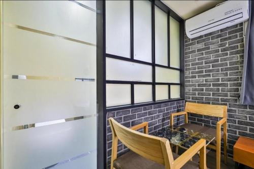 a room with a table and chairs and a brick wall at Geoje MVG Motel in Geoje 