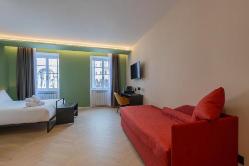 a hotel room with a bed and a red couch at Luna Stay in Trieste