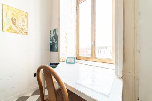 biały pokój ze stołem i oknem w obiekcie La Terrazza sui Quartieri w mieście Neapol