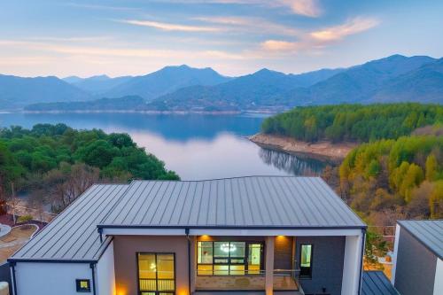 a house with a view of a lake and mountains at Jecheon The Shine Cheongpung in P'ojŏn-ni